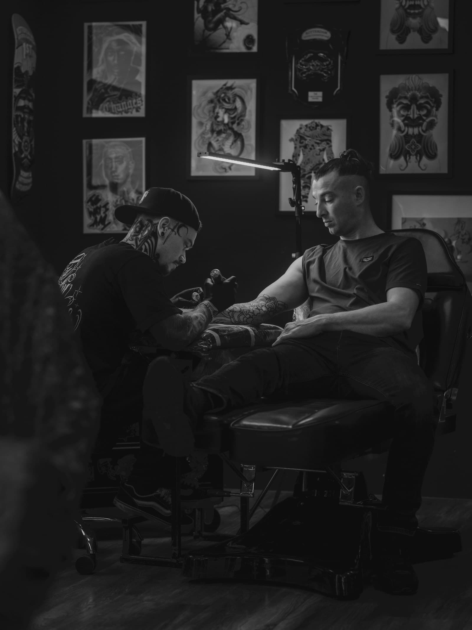 Tatoueur au travail en studio, photo en noir et blanc